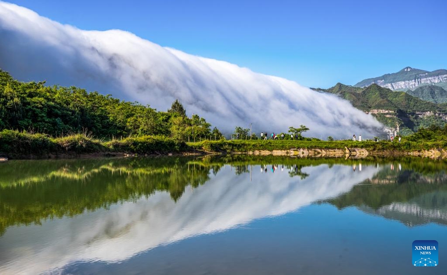 Pelancong menikmati pemandangan awan yang seakan-akan mengalir menuruni Gunung Jinfo di Chongqing, barat daya China, 13 Mei 2024. (Qu Mingbin/Xinhua)