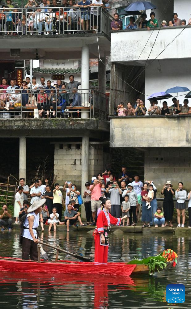 Orang ramai menonton persembahan luar di Perbandaran Wangdong di Kaunti Autonomi Rongshui Miao di Wilayah Autonomi Guangxi Zhuang, selatan China, 18 Ogos 2024. Sejak beberapa tahun mutakhir, Perbandaran Wangdong telah memanfaatkan sumber airnya yang banyak untuk menggalakkan daya hidup luar bandar. Disokong oleh "bantuan berpasangan" dari Bandar Lianjiang di Provinsi Guangdong, perbandaran itu berjaya menganjurkan pertandingan sukan air, nyanyian duet lagu gunung dan aktiviti bertemakan warisan budaya tidak ketara di sekolah. Inisiatif ini bertujuan untuk membina jenama "budaya air" dan memajukan pembangunan pelancongan budaya etnik. (Xinhua/Huang Xiaobang)